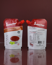 Two Sausome Amla Chutney packets on a reflective surface with a dark background