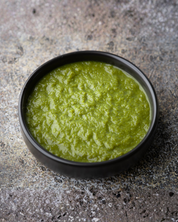 Bombay Chutney in a black bowl on a textured stone surface