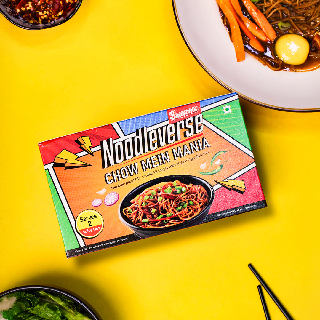 Chow Mein Mania noodle pack styled with fresh vegetables and chopsticks