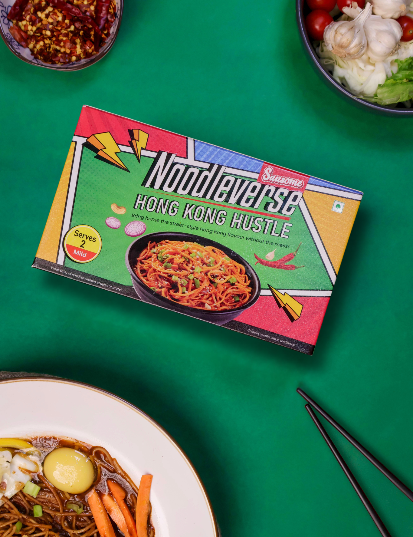 Noodlaverse Hong Kong Hustle noodle box on a green background with noodles and vegetables.