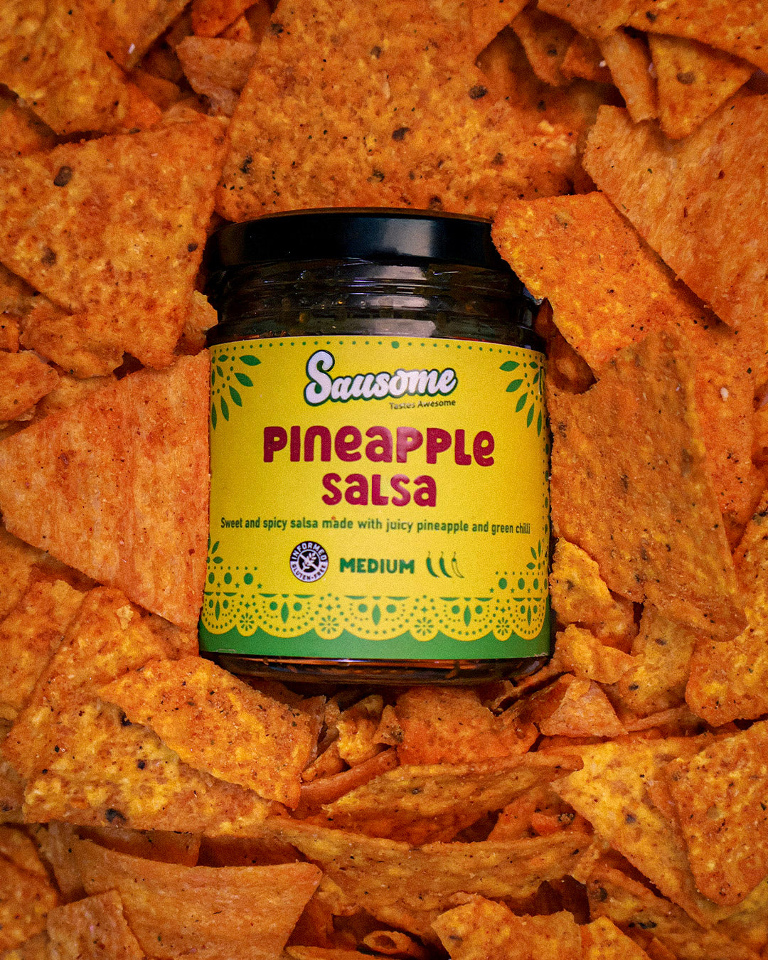 Jar of Sausome Pineapple Salsa on a bed of tortilla chips